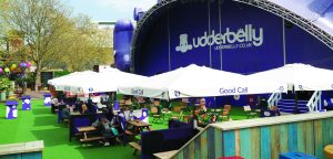 The Udderbelly Festival Cowsgate Edinburgh in Scotland. Comedy events at the Edinburgh Fringe. Large parasols branded with Fosters Larger logo’s