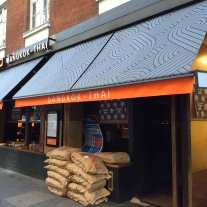 All over branding of Busaba restaurant in London City Centre. Awning cover printed in black, with contrasting orange valance printed in white By Parker Masters Ltd.