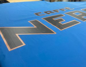 Replacement awning cover for Caffe Nero. Light blue awning cover branded with 2 colour colour. Parker Masters Ltd., supply branded or blank replacement awning covers.
